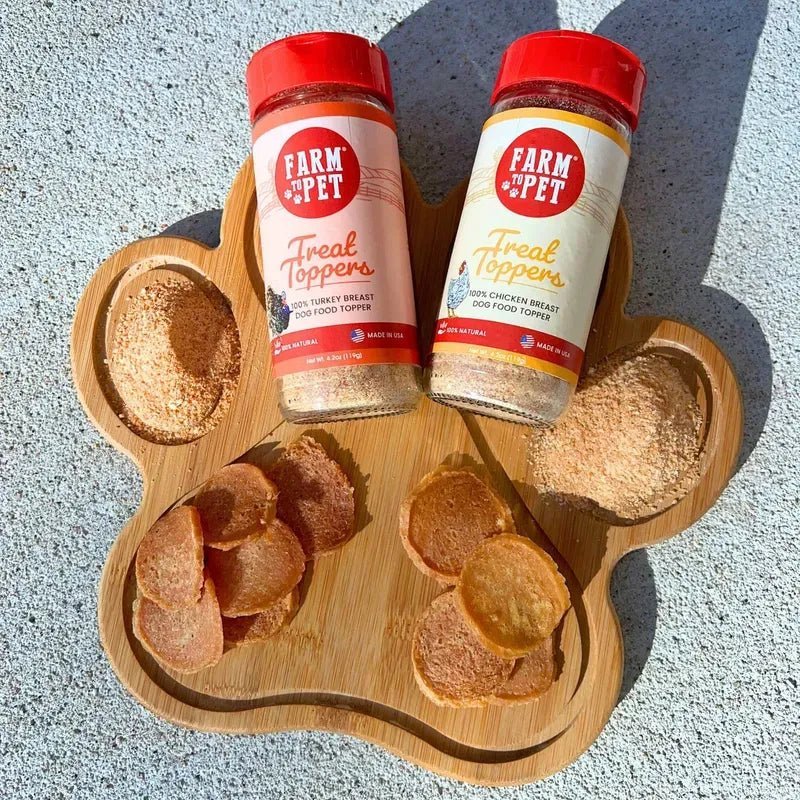 Dog food treat topper bundle with two jars and bone-shaped treats on wooden tray.