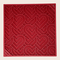 Red dog lick mat with heart swirl pattern and corner mounting holes