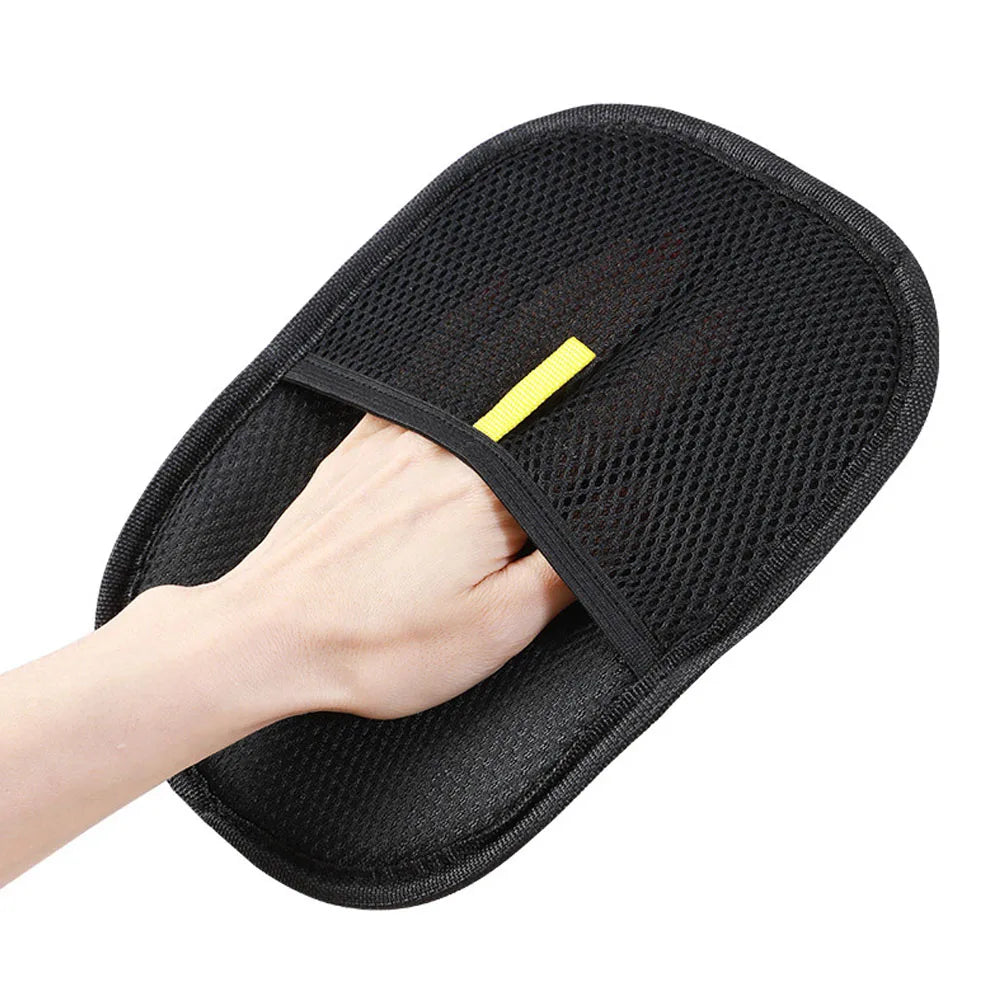 Black pet grooming glove worn on hand, textured mesh palm with neon yellow tab