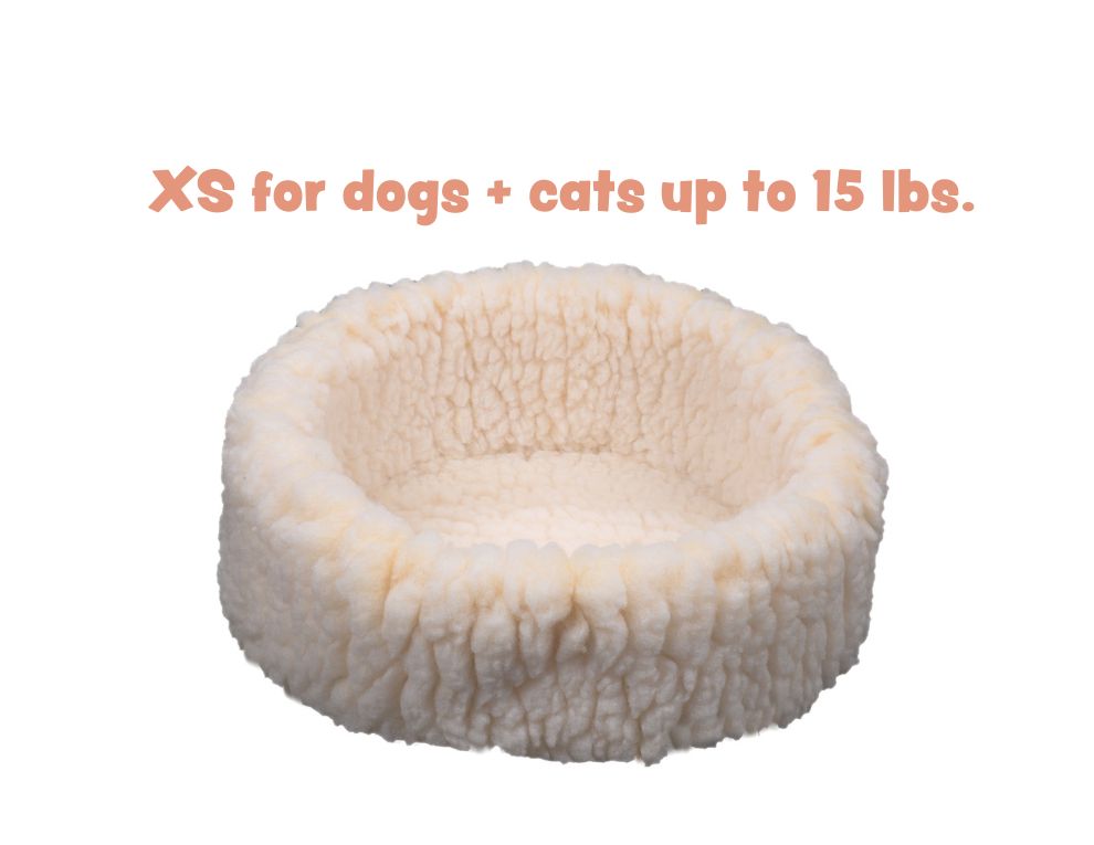 Round cream sherpa pet bed with plush raised rim