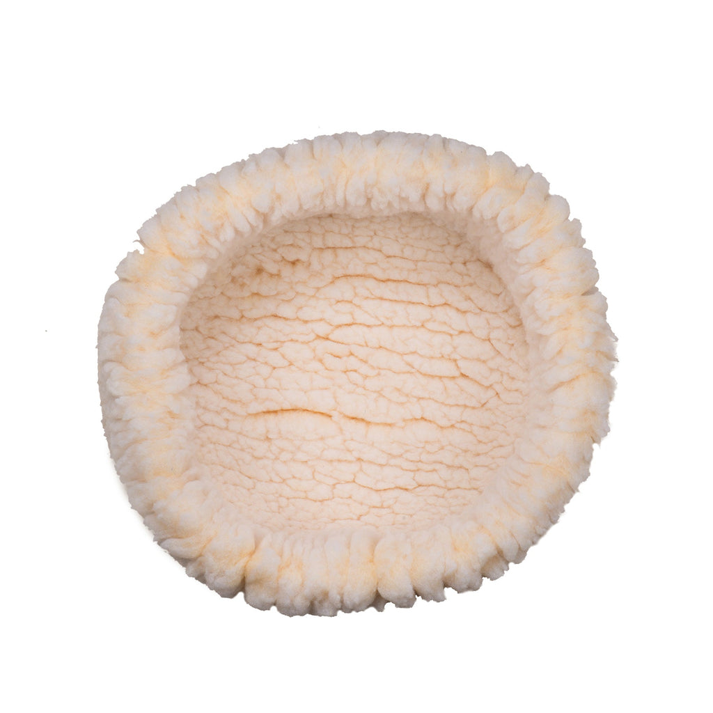 Round cream sherpa pet bed with fluffy open center and cushioned edge