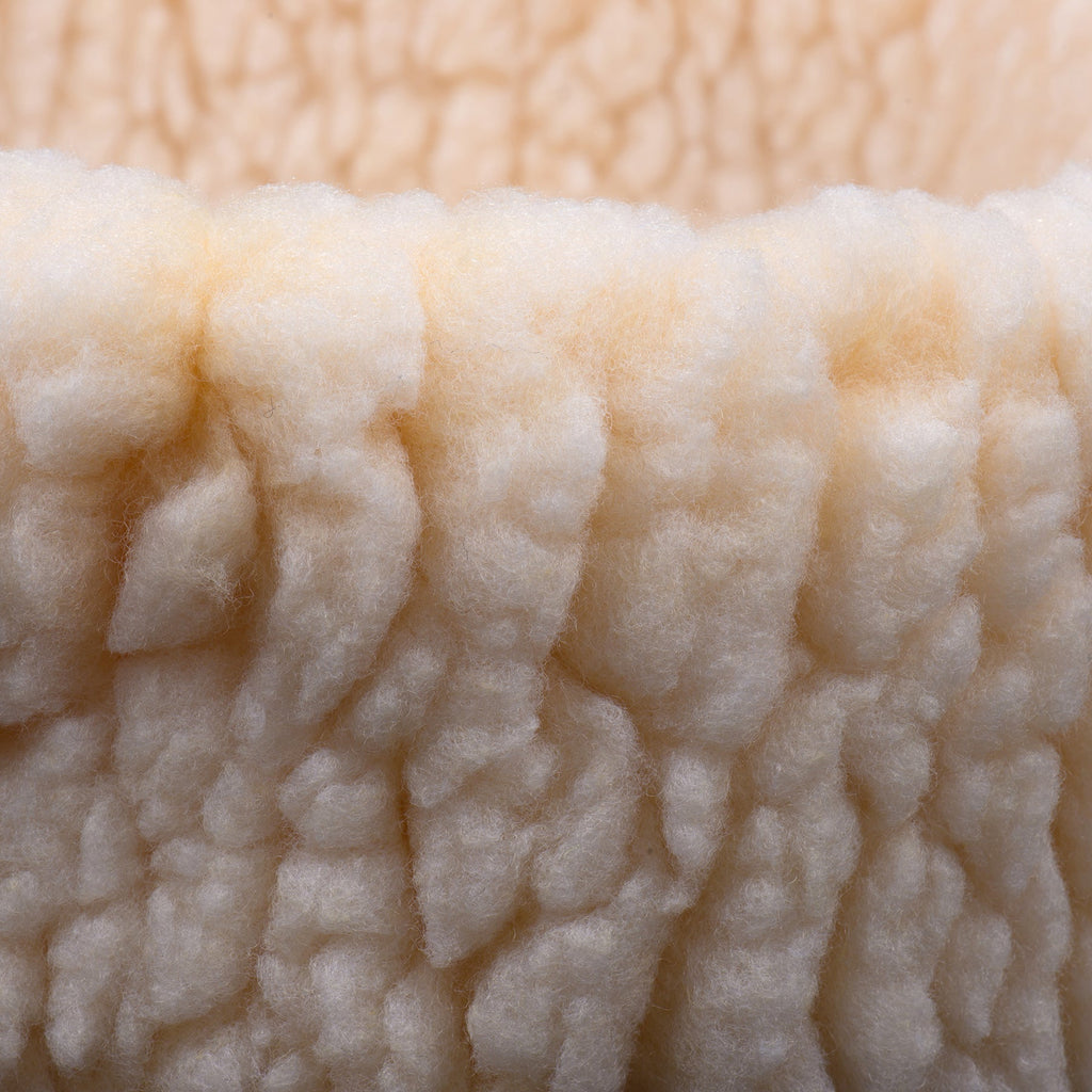 Cream sherpa fabric close-up with thick curly plush texture