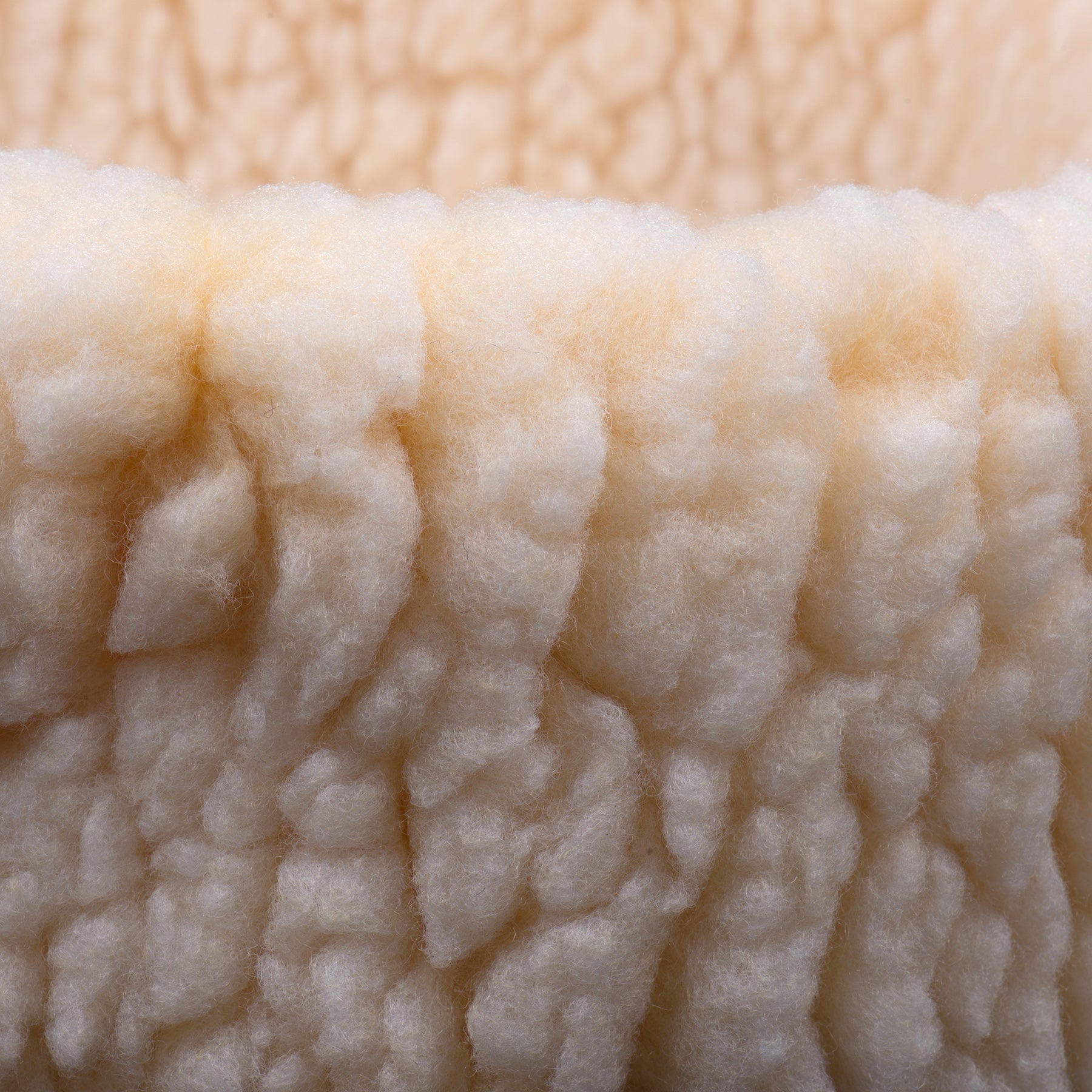 Cream sherpa fabric close-up with thick curly plush texture